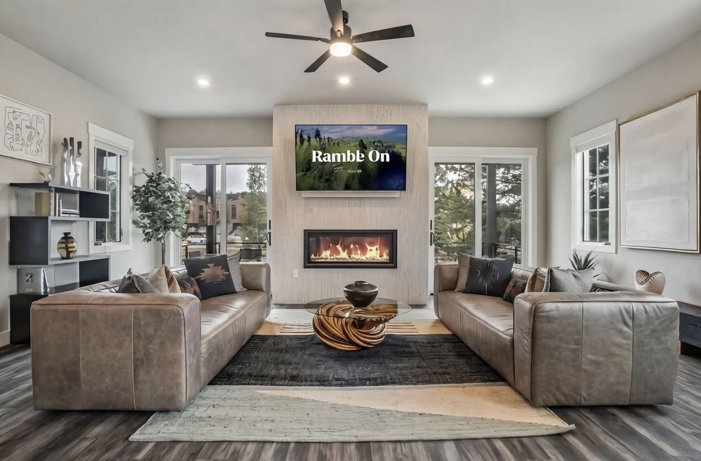 Great room with twin leather sofas and linear fireplace