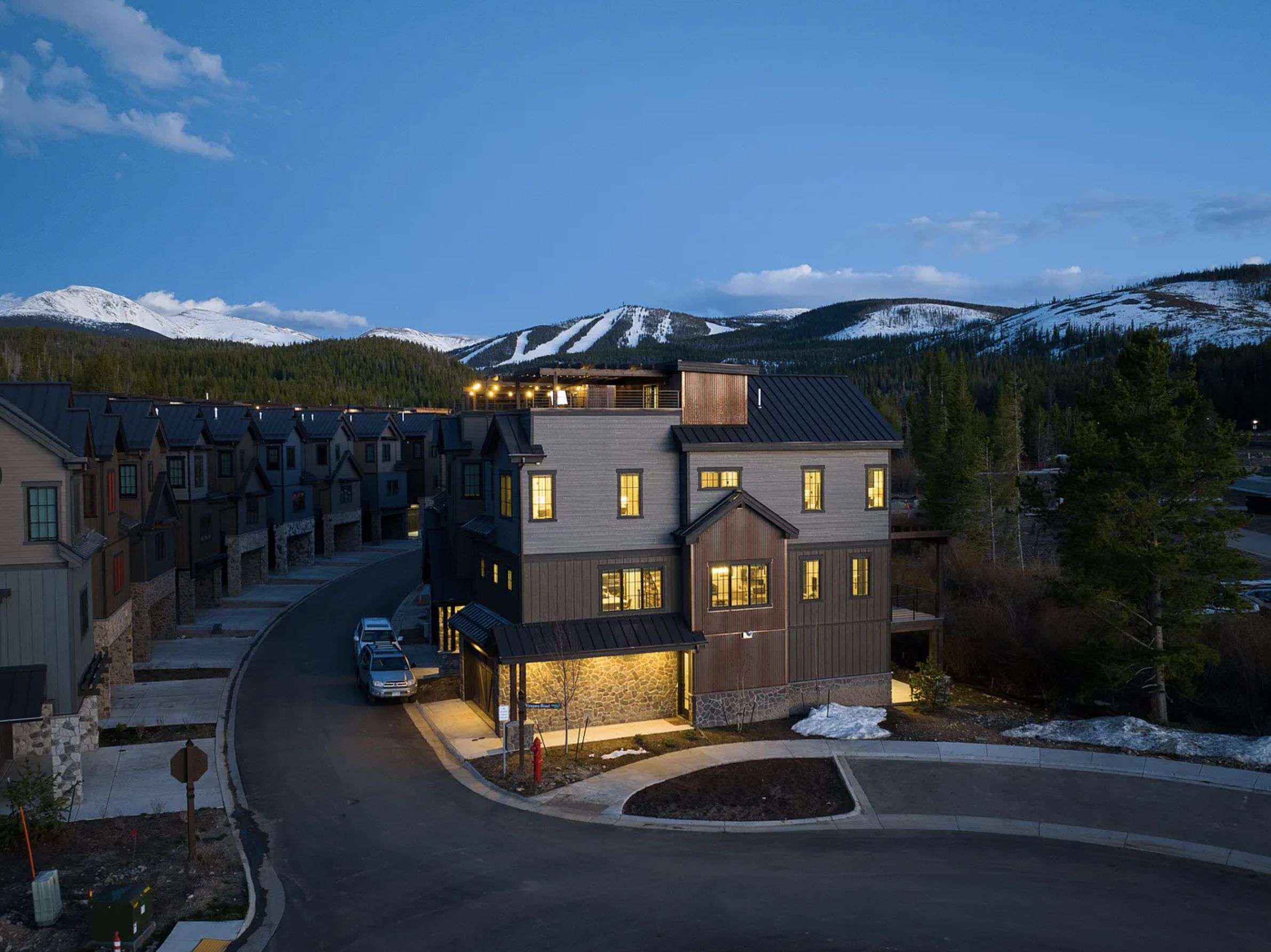 The home at twilight with the ski runs behind